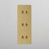 Six Lever Triple Vertical Toggle Switch in Antique Brass on White Background