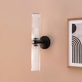 Claremont Medium Wall Light Fluted Glass in Bronze affixed to a wall with wooden framed picture