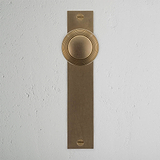 Poplar Long Plate Sprung Door Knob Antique Brass Finish on White Background right Facing Front View