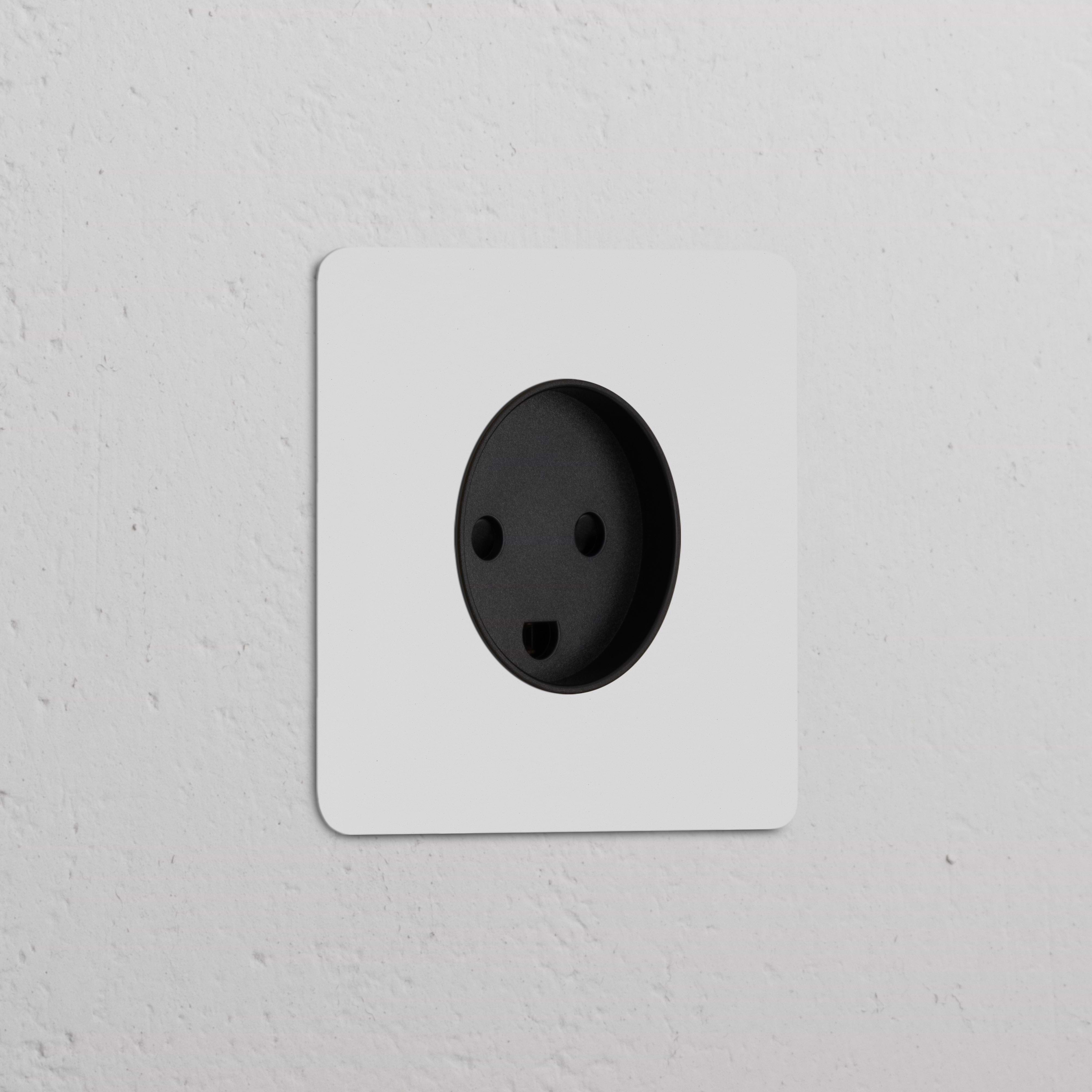 A paintable black Single Danish Type K Power Module Round socket on a textured white wall.