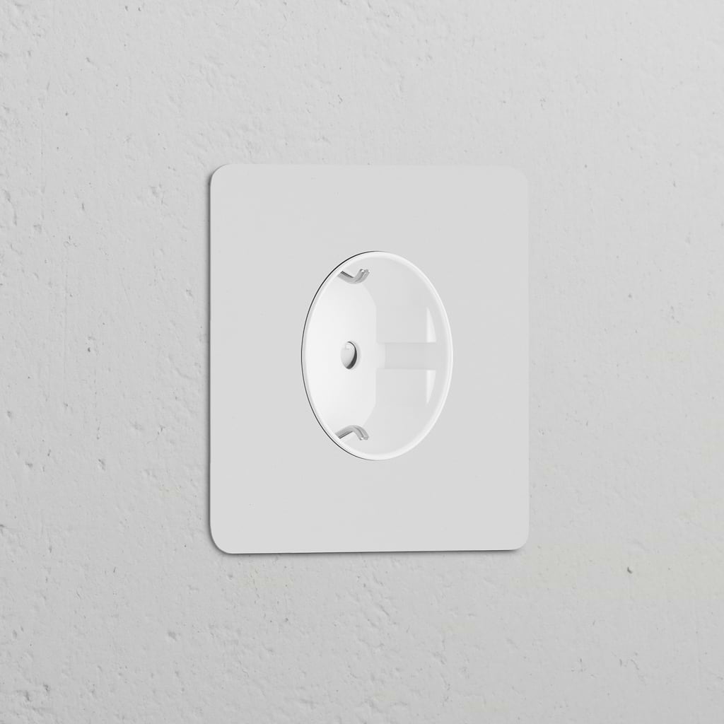 Paintable white Single Schuko Type F Power Module for electrical sockets blends into a light grey wall.