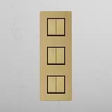 Six Position Triple Vertical Rocker Switch in Antique Brass Black on White Background