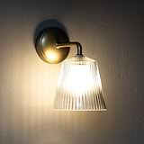 Richmond Medium Wall Light Fluted Glass Antique Brass Finish White Background affixed to a wall and turned ON