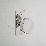 Onslow Short Plate Sprung Door Knob Polished Nickel Finish on White Background at an Angle