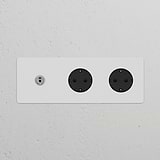 Triple toggle switch with 2 Schuko type F sockets in paintable polished nickel on a white wall.