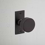 Onslow Short Plate Sprung Door Knob Bronze Finish on White Background at an Angle