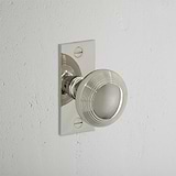 Poplar Short Plate Sprung Door Knob Polished Nickel Finish on White Background at an Angle