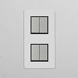 Double 4x vertical rocker switch in paintable polished nickel black on a white textured wall.