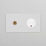 White faceplate with double toggle switch and Danish Type K power module in antique brass finish.