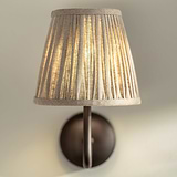 Small Malvern Wall Light in Natural Beige front facing close up of pleated shade and turned on 