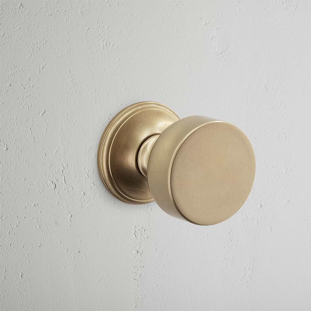 Onslow Sprung Door Knob Antique Brass Finish on White Background  