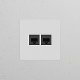 Single 2x RJ45 Module in paintable black, ideal for networking installations, against a textured white wall.