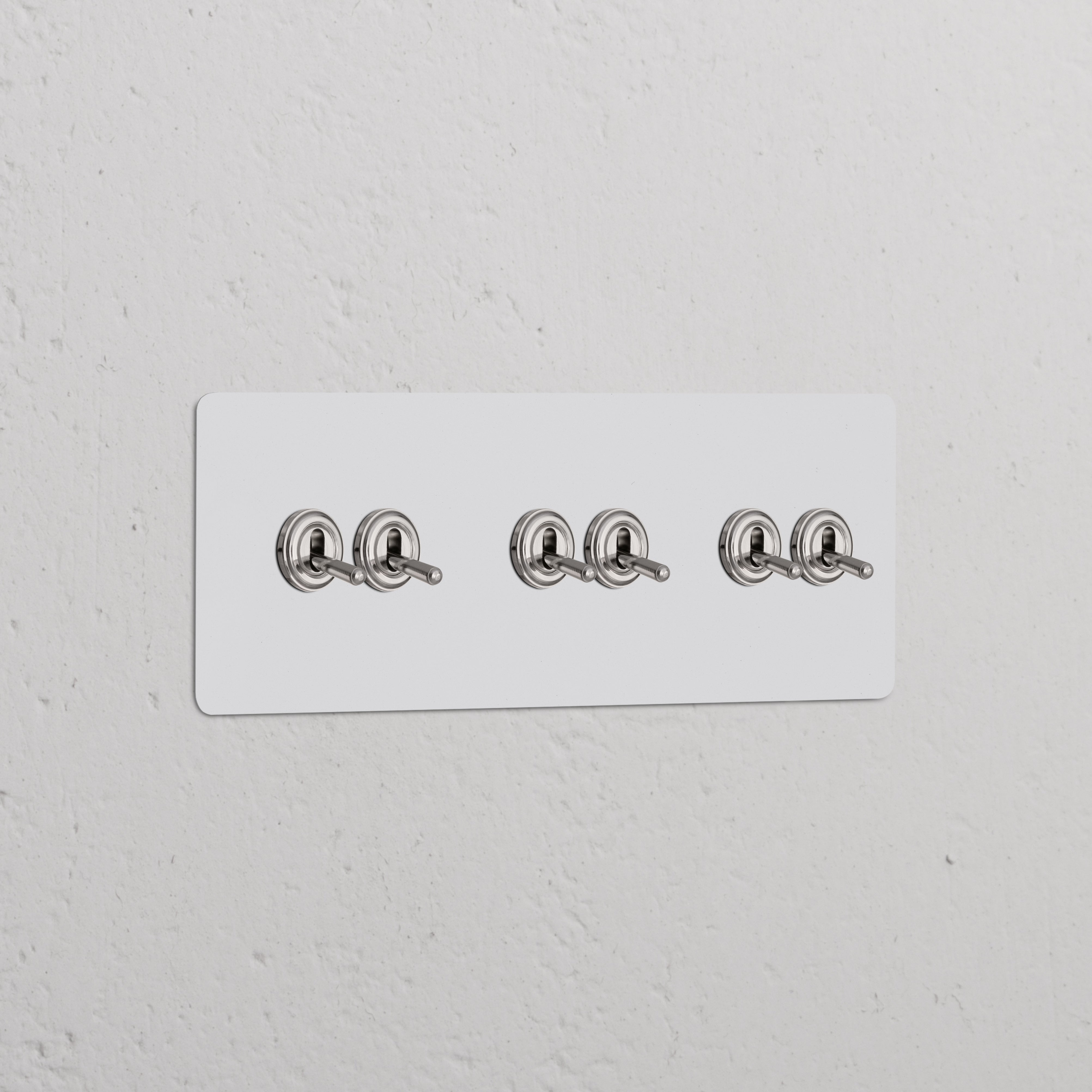 Triple 6x Toggle Switch Paintable Polished Nickel on a white panel against a textured wall.