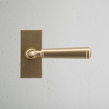 Digby Short Plate Fixed Door Handle Antique Brass Finish on White Background Front Facing