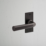 Apsley Short Plate Sprung Door Handle Bronze Finish on White Background at an Angle