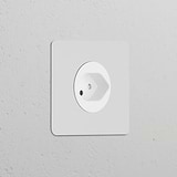Single Swiss Type J power module socket, round and paintable white, for a seamless fit in electrical installations.