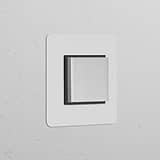 Single Rocker Switch in Polished Nickel and Black on a white wall, suitable for switches and dimmers use.
