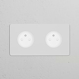 White, paintable double socket with a 2x French/Belgian Type E power module for versatile electrical connections.