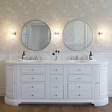 Claremont Medium Wall Light Fluted Glass in Polished Nickel affixed to a floral wall papered wall alongside a silver mirror above a marble bathroom sink
