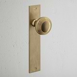Poplar Long Plate Sprung Door Knob Antique Brass Finish on White Background at an Angle