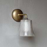Richmond Medium Wall Light Fluted Glass Antique Brass Finish affixed to a grey wall