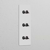 Triple 6x Vertical Toggle Switch in Paintable Bronze, part of Triple Vertical Switches & Dimmers collection.
