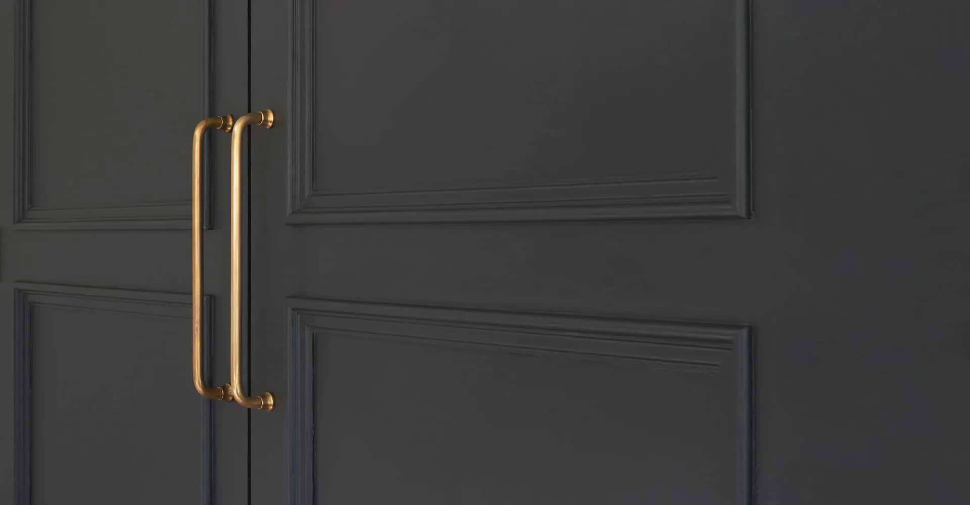 Poignées de porte en laiton ancien Corston sur porte noire