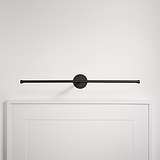 L'applique murale minimaliste en bronze Taylor Picture Light 580 mm est élégamment montée au-dessus d'un mur blanc encadré.