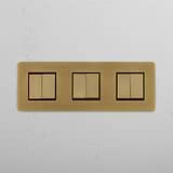 Triple Rocker Switch with Six Positions in Antique Brass Black on White Background