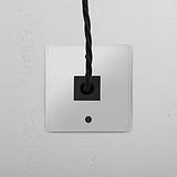 Sortie de Câble (Plaque Simple) en noir transparent sur mur blanc ; conçue pour la gestion des câbles.
