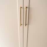 Poignée de meuble en Sycomore en Laiton Ancien 384mm montée sur une porte de meuble crème, zoomé. 