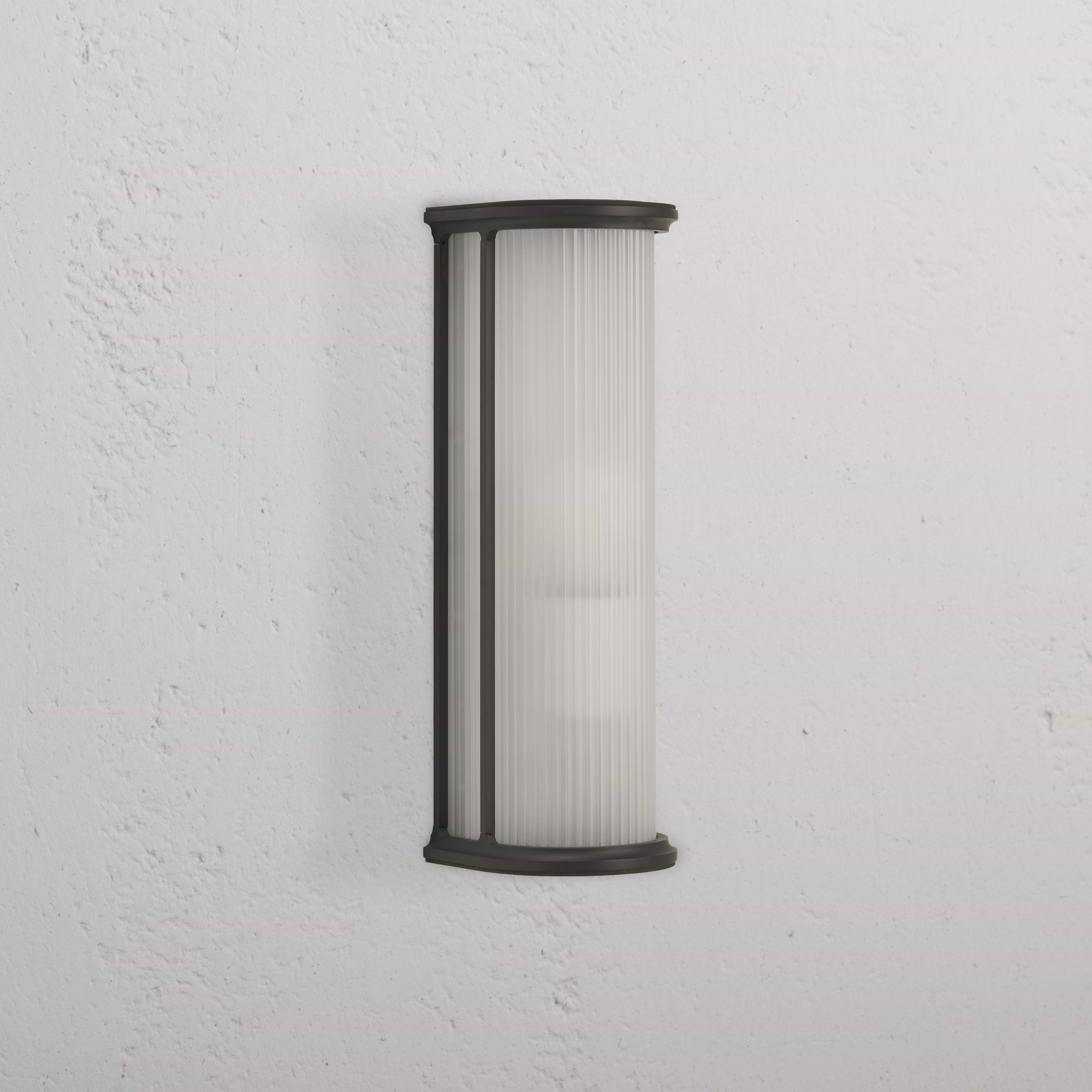 Applique murale de taille moyenne, Bank Applique Verre CannelÃ© - Bronze, avec verre nervurÃ© et cadre en mÃ©tal bronze sur mur blanc.