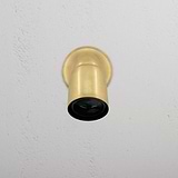 Projecteur Encastré Ealing en Laiton Ancien sur mur texturé blanc, diffusant une lumière chaude et vintage.