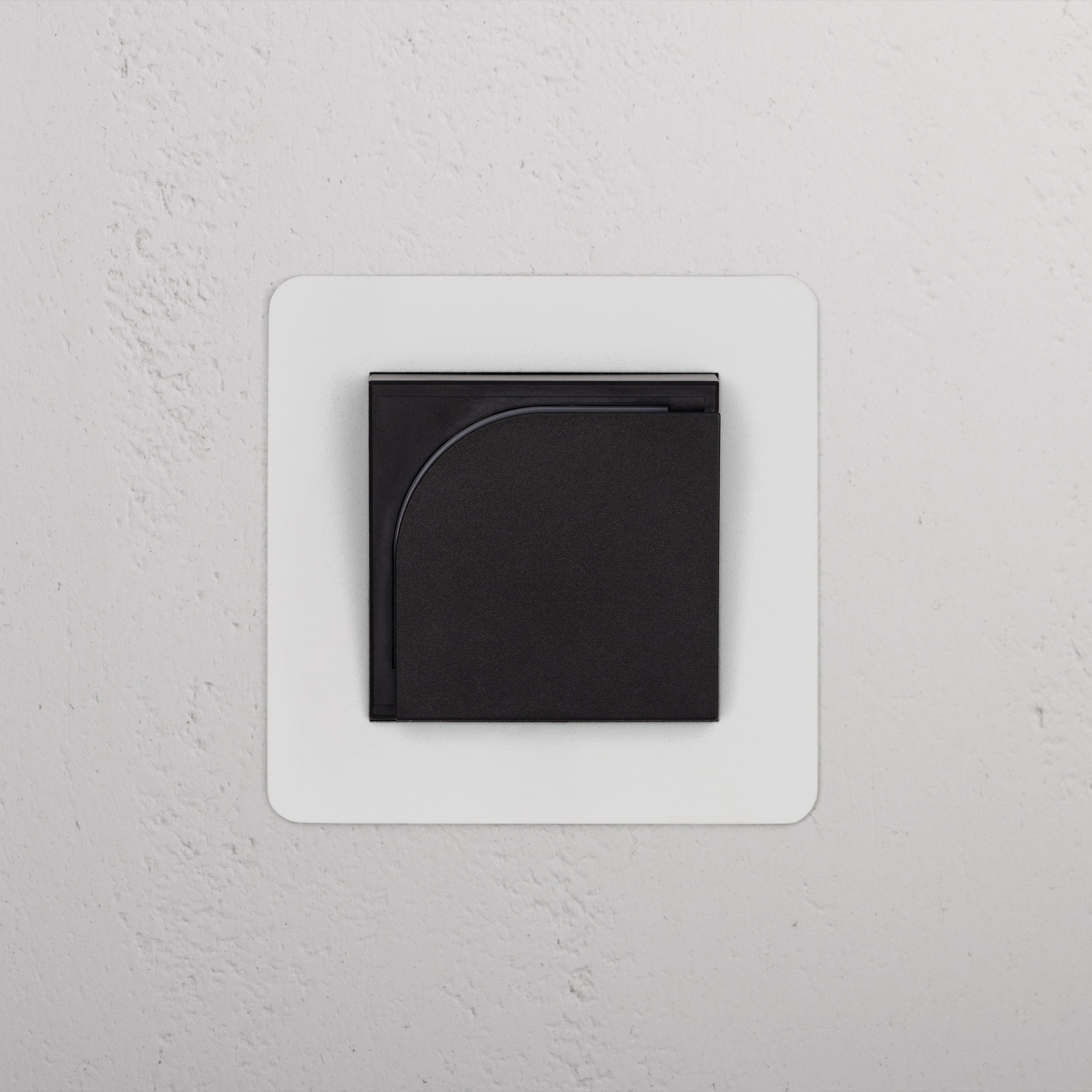 Lecteur de cartes d'hôtel noir - insert à peindre, conçu pour Prises & Modules Simple, sur un mur texturé blanc.