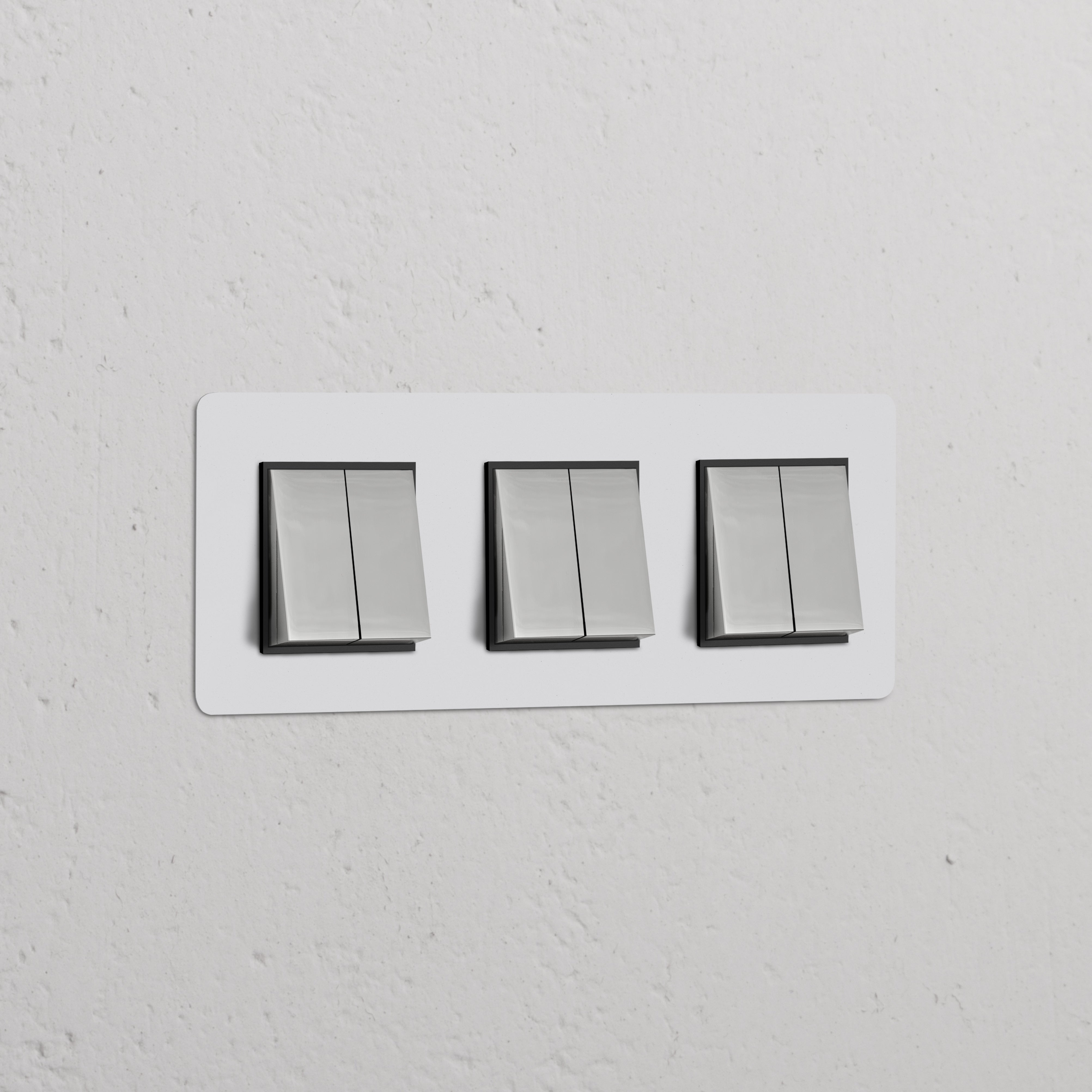 Interrupteurs VV Carré x6 (Plaque Triple) en nickel avec insert noir sur un mur, design moderne à triple interrupteur.