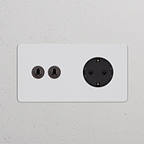 Módulo duplo redondo em bronze pintável com interruptor articulado bidirecional e tomada Schuko Tipo F na cor preta.