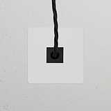 Tomada de cabo individual – Pintável Preto, tomada elétrica preta sobre uma parede texturizada branca.