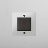 Interruptor basculante individual central em Bronze Transparente Preto para gestão de luz eficiente em fundo branco