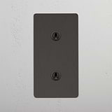 Interruptor articulado duplo vertical em Bronze em fundo branco