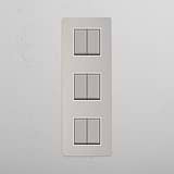 Interruptor basculante de seis unidades vertical em Níquel Polido Branco em fundo branco