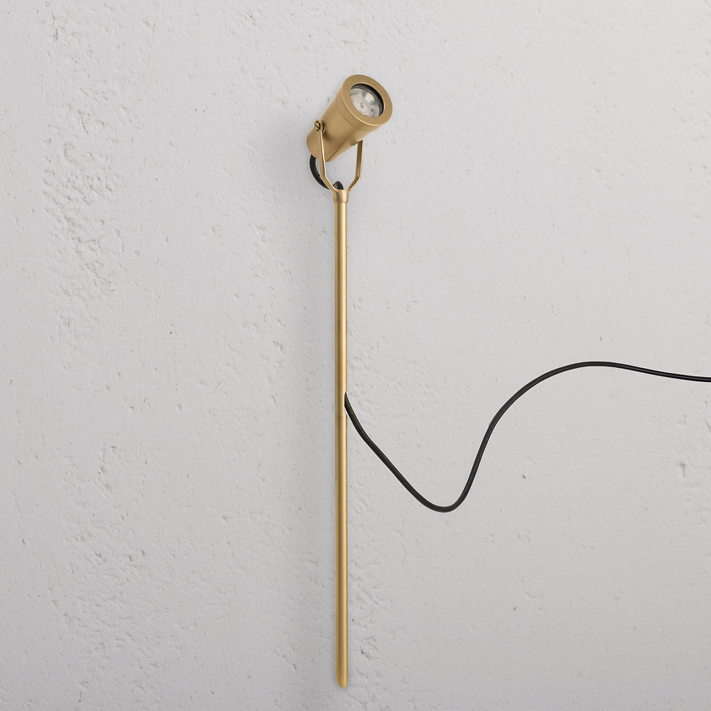 Cambridge Ground Spotlight 24V outdoor spotlight in antique brass, featuring an angled head and black cord.