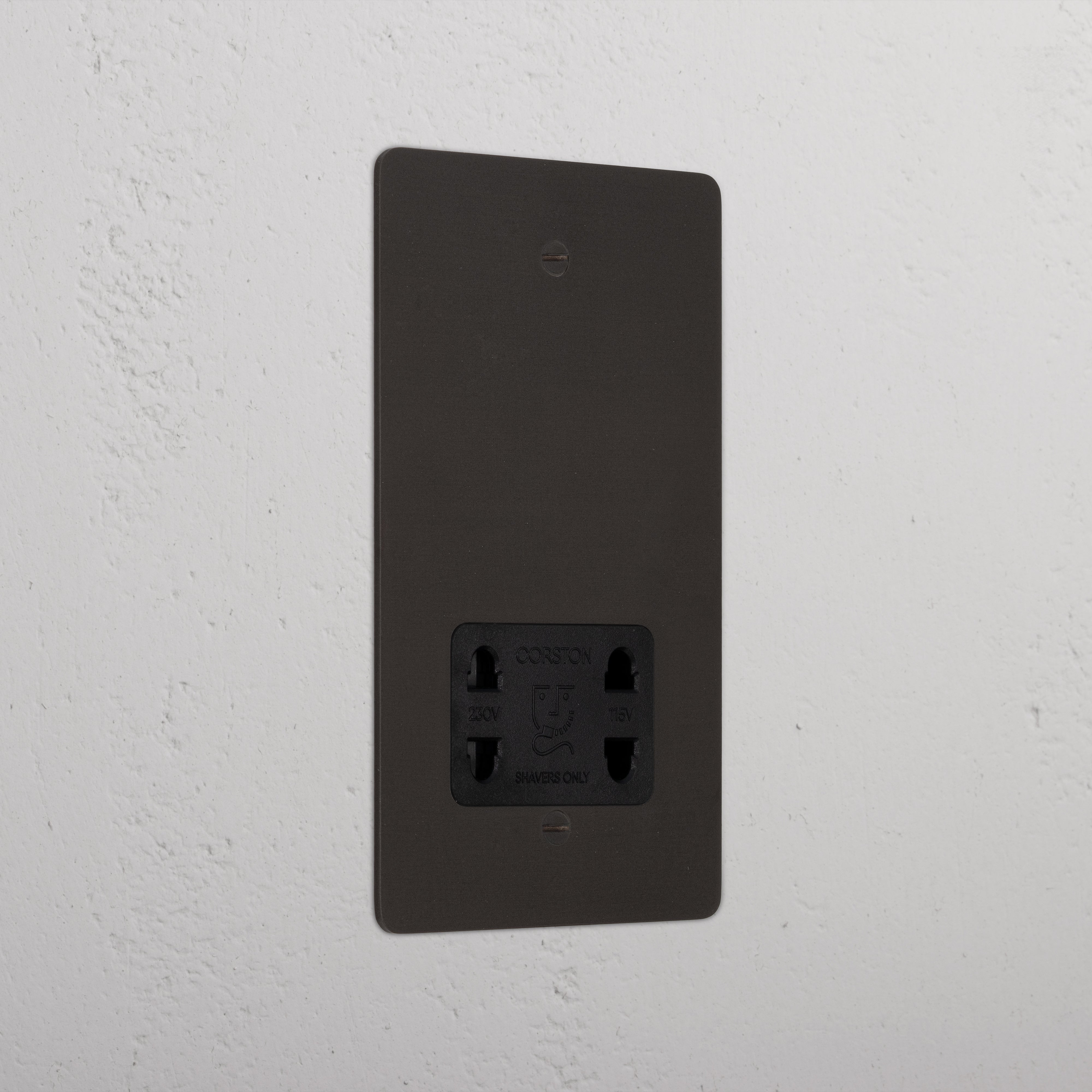 Bronze shaver socket with black insert on grey wall. 