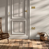 Bronze 3G two way toggle switch fixed to cream wall next to cream wooden door with antique brass door handle and aged wooden floorboards 