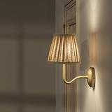 Medium Malvern Wall Light in Natural Beige side view affixed to a wall and turned on