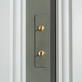 Close-up of a 2G architrave two-way toggle switch with paintable antique brass finish.