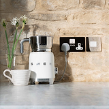 Polished Nickel White switched fuesed spur set in stone wall next to white coffee machine and cream mug 