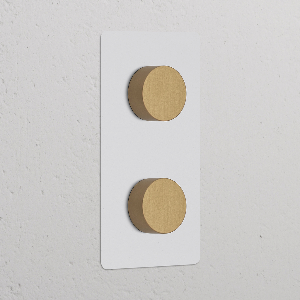 Vertikaler Zweifachrahmen mit 2x Mehrpunkt-Dimmerschalter, lackierbar und antikes Messing, ein weißer Wand.