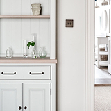 Bronze Sycamore Furniture Handle on Cream Cupboard Furniture Next to Light Switch