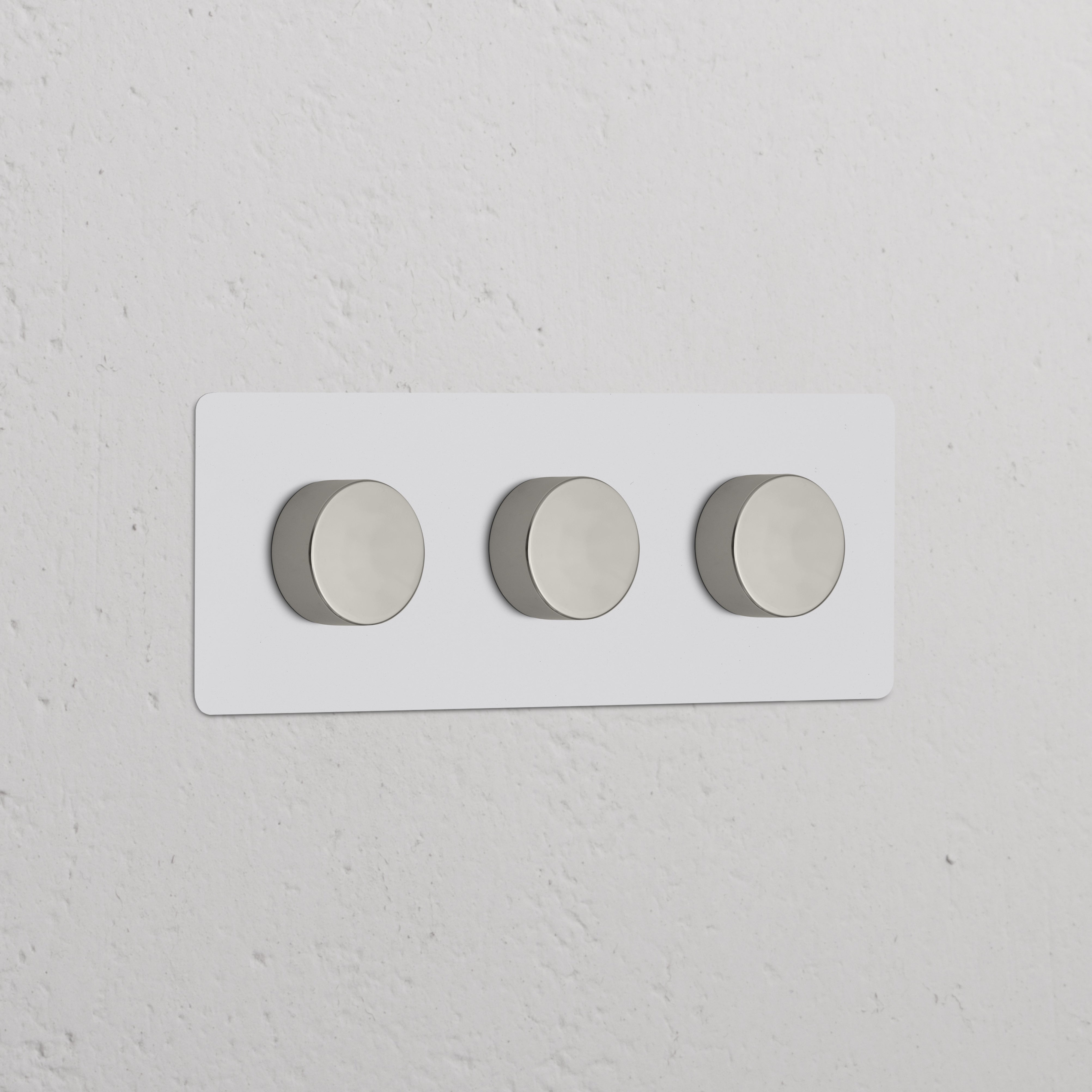 Dreifachrahmen mit 3x Mehrpunkt-Dimmerschalter, lackierbar und poliertes Nickel, horizontal angeordnet.