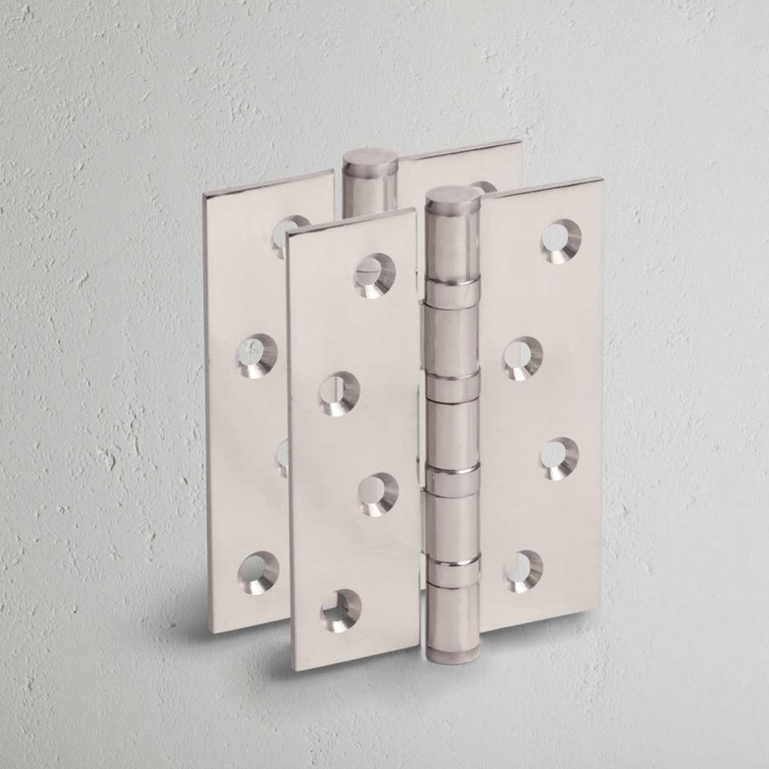 Polished Nickel Curtis Door Hinge Pair on White Background